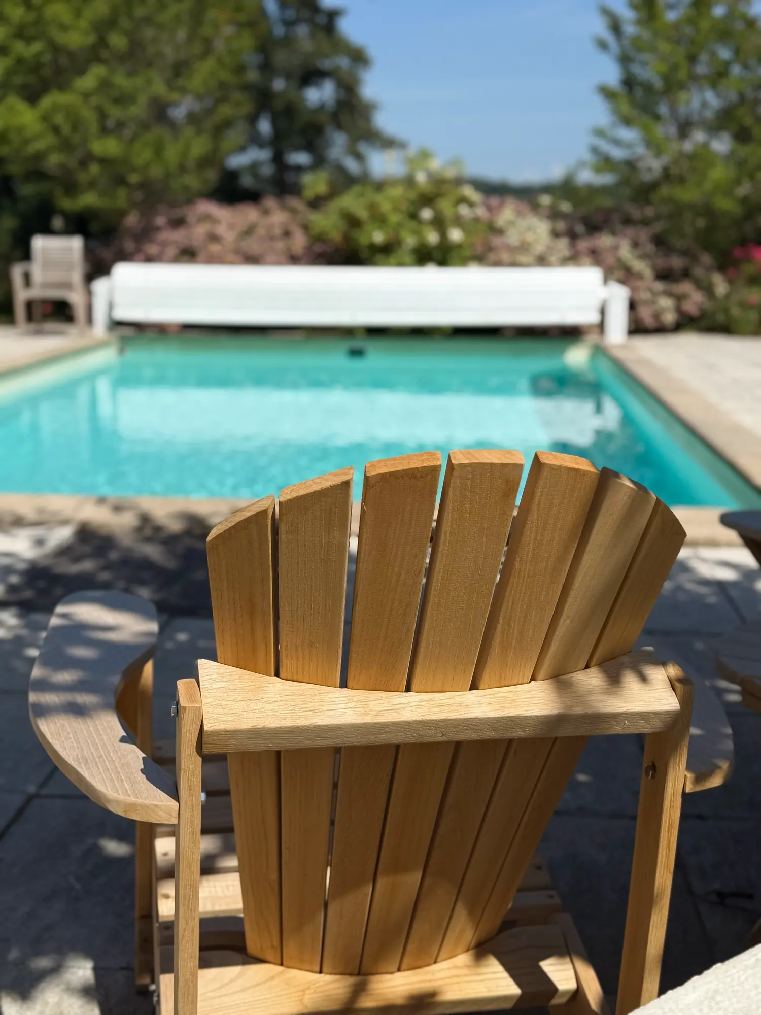Un transat en bois au bord de la piscine turquoise de La Pradella