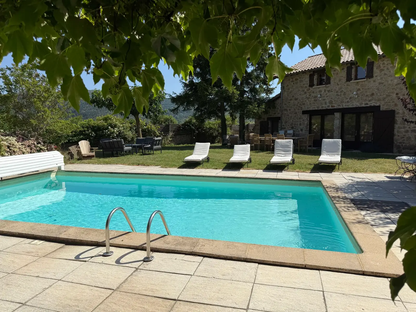 La piscine bordée de bains de soleil, dans le jardin de La Pradella