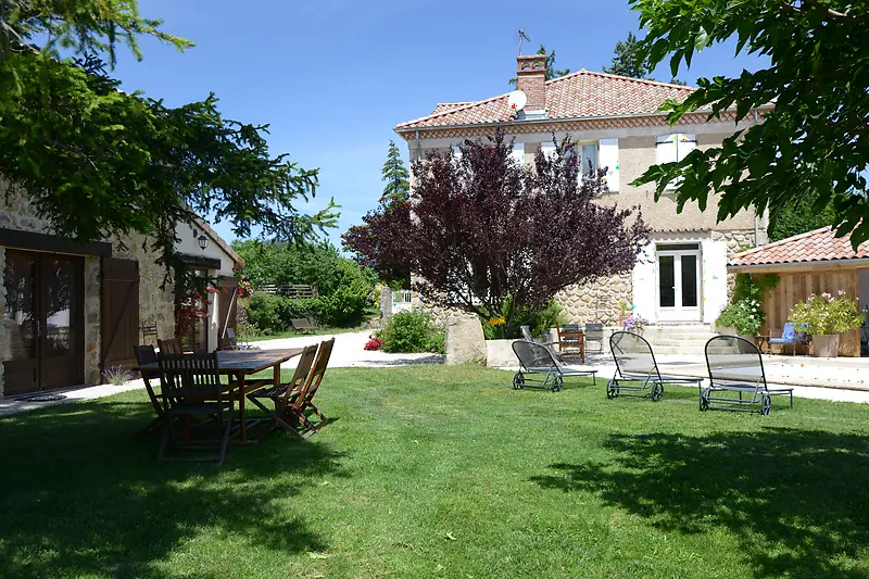 Le grand jardin de La Pradella, sa table de jardin et ses bains de soleil devant le mas