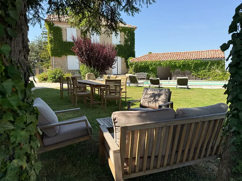 Le salon de jardin en teck sur la pelouse, devant la bâtisse en pierre de La Pradella