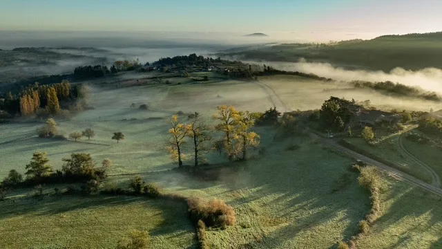 Paysage de l'Ardèche Verte au lever du soleil, brume matinale sur les collines et les forêts autour de Préaux