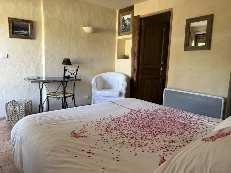 La Piscine : la chambre aux murs ocre, avec son lit double, son bureau ancien et son fauteuil