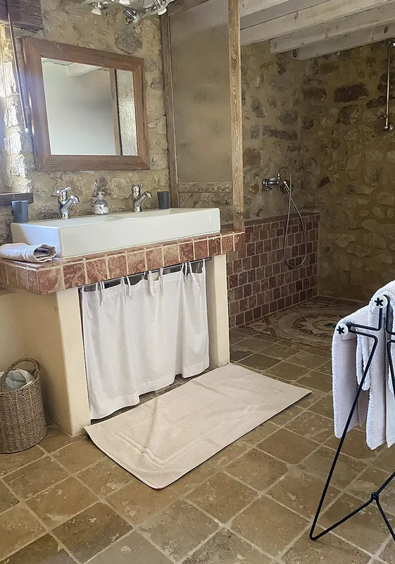 La Suite : la grande salle de bain en pierre, sa vasque et sa douche à l'italienne